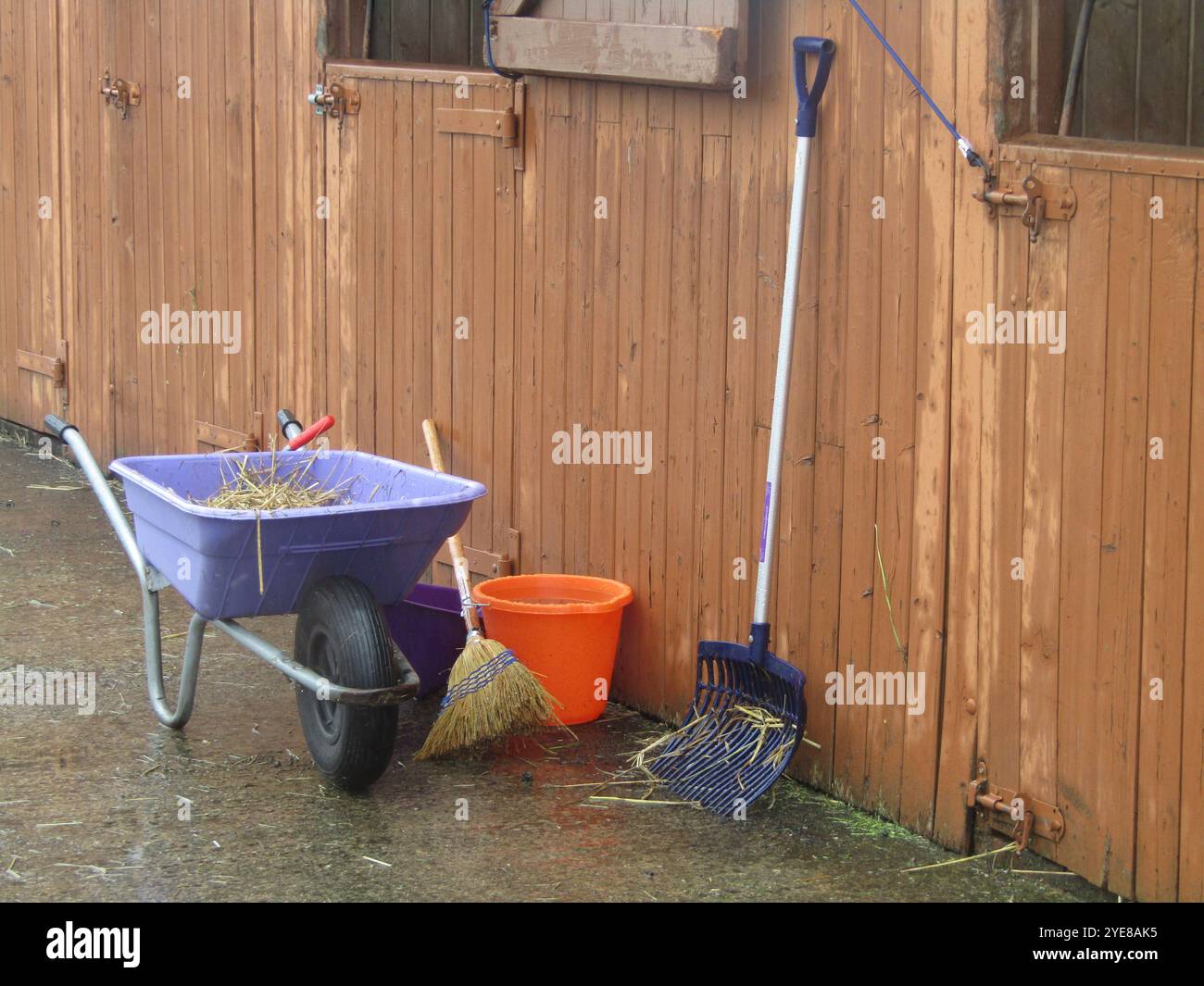 Eine Schubkarre und Werkzeuge, um einen Pferdestall auszumustern. Stockfoto