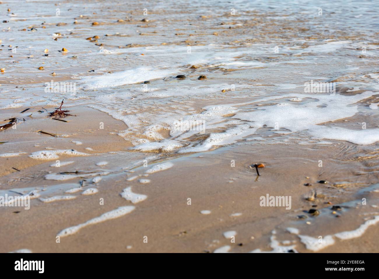 Nahaufnahme des Meerwassers, das auf einen Sandstrand läuft. Stockfoto