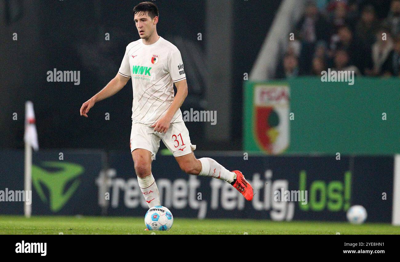 Augsburg, Deutschland. Oktober 2024. Keven Schlotterbeck aus Ausgburg ist mit dem Ball bei seinem DFB-Fußball-Spiel zwischen dem FC Augsburg und Schalke 04 im WWM Arena Stadion zu sehen . Quelle: Davide Elias / Alamy Live News Stockfoto