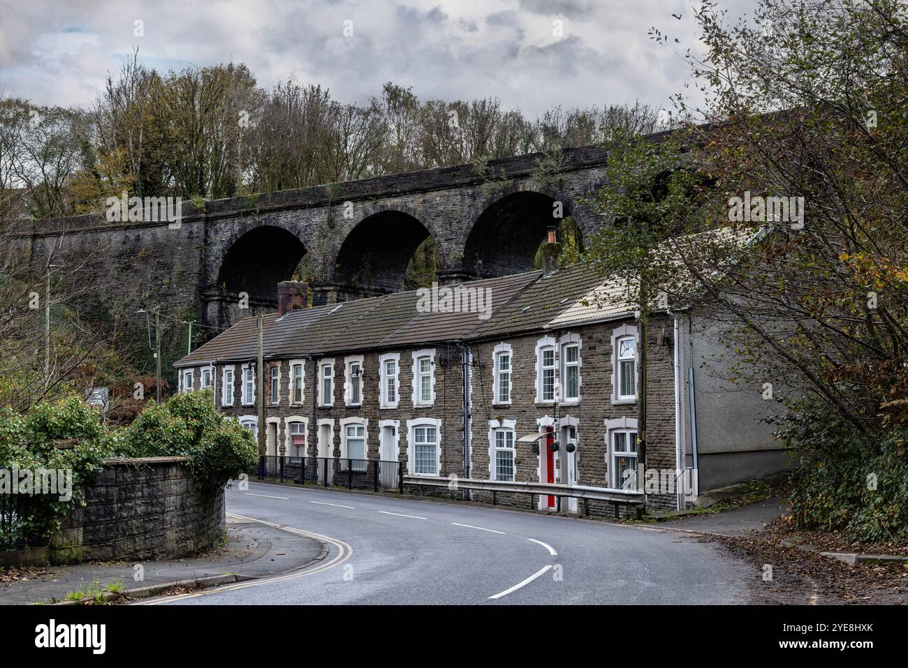 Steinterrassenhäuser unterhalb des Bargoed Viaduct, Aberbargoed, Caerphilly, Wales, Großbritannien Stockfoto