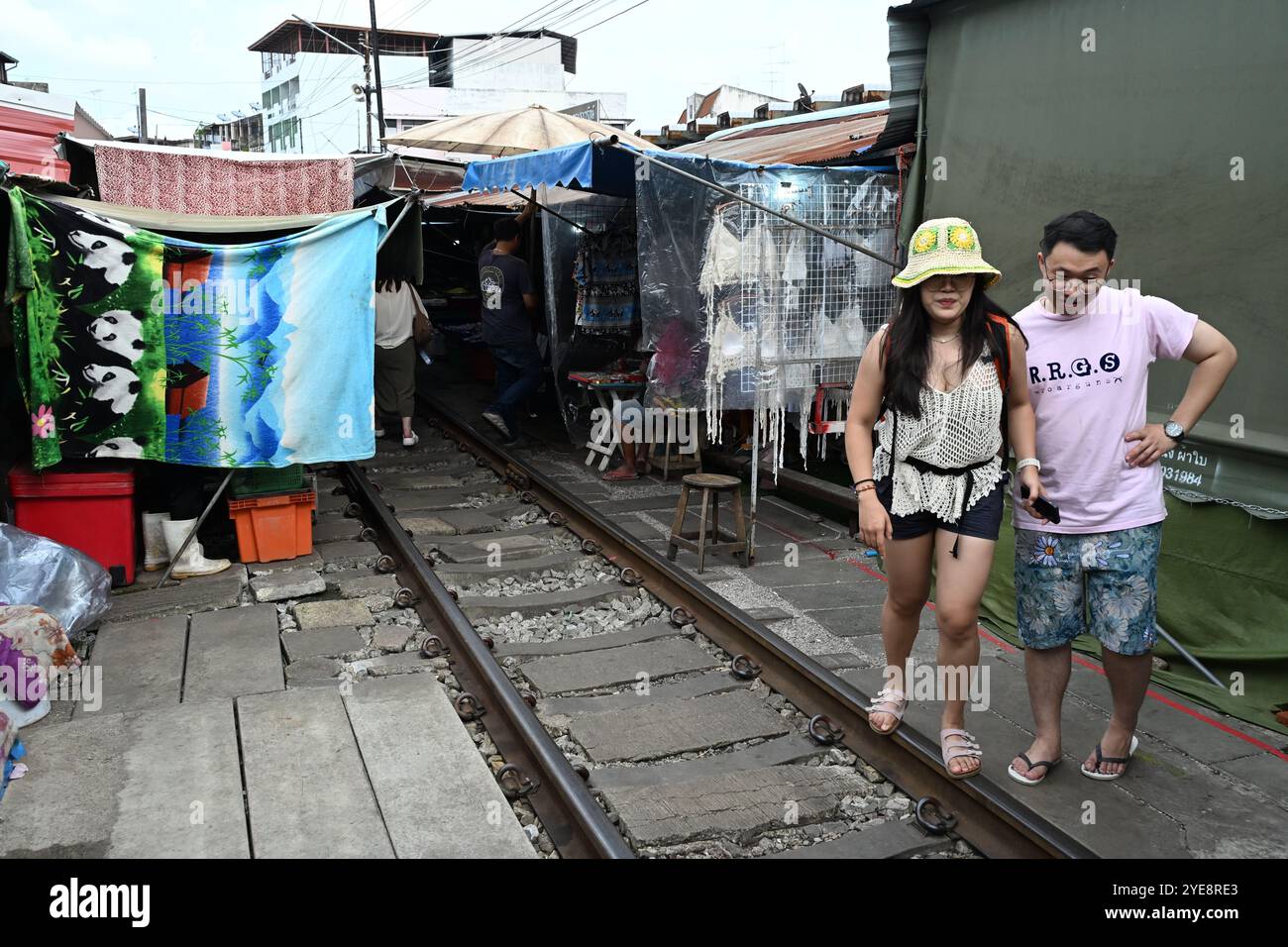 Eisenbahnmarkt Thailand, Touristen Paar zu Fuß entlang der Bahngleise in Railway Market, Maeklong Railway , Thailand , Bangkok , Asien Stockfoto