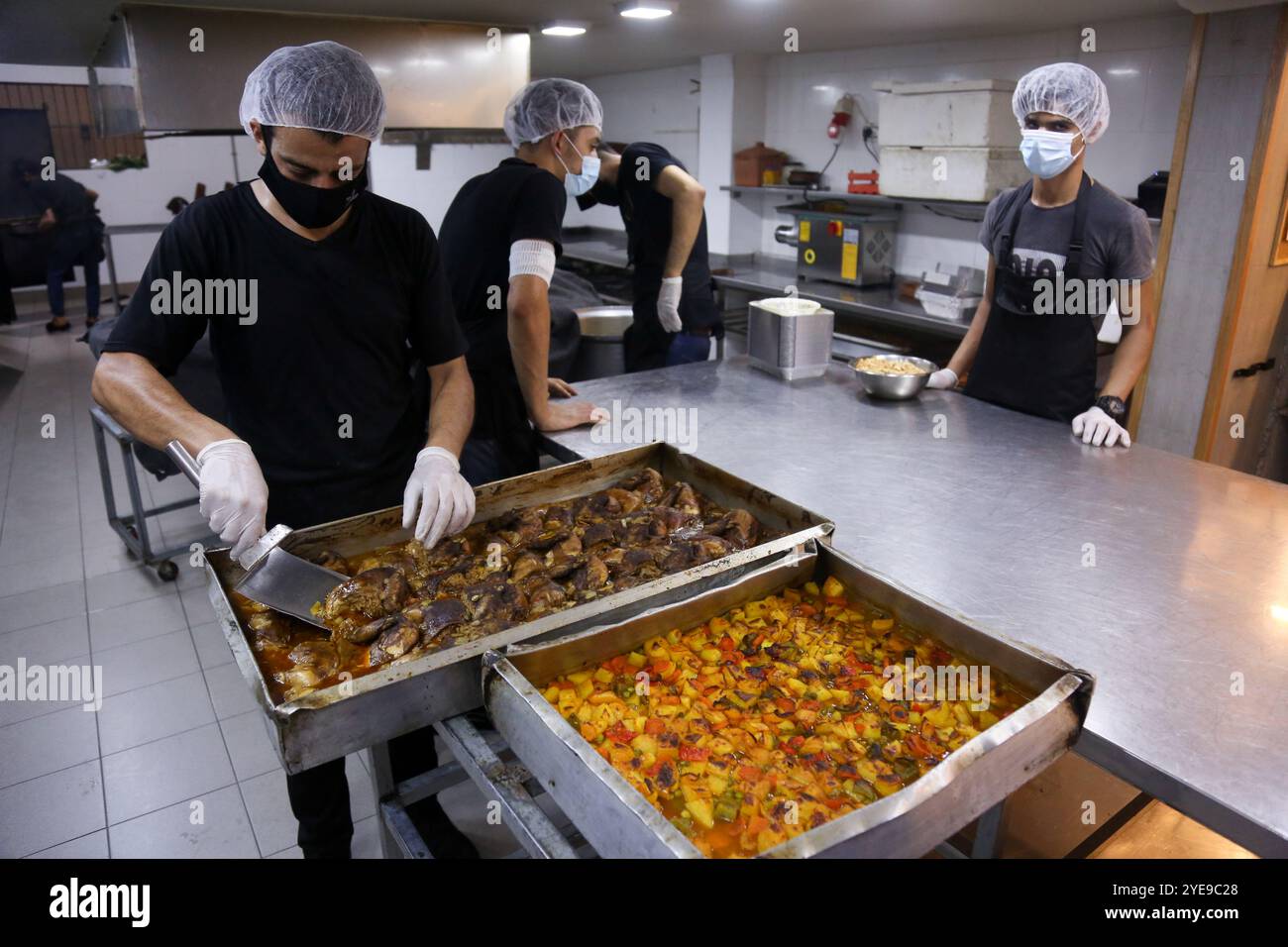 Gaza, Palästina. August 2020. Hunderte von Mahlzeiten werden zubereitet, um Menschen in den Quarantänezentren in Gaza-Stadt zu ernähren. In der vergangenen Woche wurden erstmals COVID-19-Fälle in der Gemeinschaft des dicht besiedelten Gazastreifens entdeckt, was tiefe Bedenken darüber aufwirft, dass sein überlastetes und unzureichendes Gesundheitssystem bald überfordert werden könnte. Die Fälle des Coronavirus haben in der belagerten Küstenenklave in der Tat stetig zugenommen, da die Gesundheitskrise durch die aktuellen Spannungen mit Israel verschärft wurde, die verhindern, dass Treibstoff in Gaza eindringt und schwere Stromknappheit verursacht Stockfoto