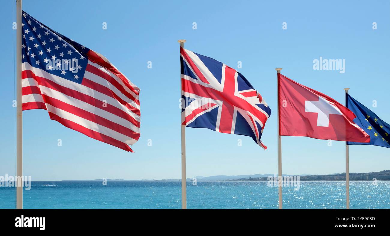Die Flaggen der Vereinigten Staaten, Großbritanniens, der Schweiz und der Europäischen Union im Wind an der Küste von Nizza, Frankreich Stockfoto