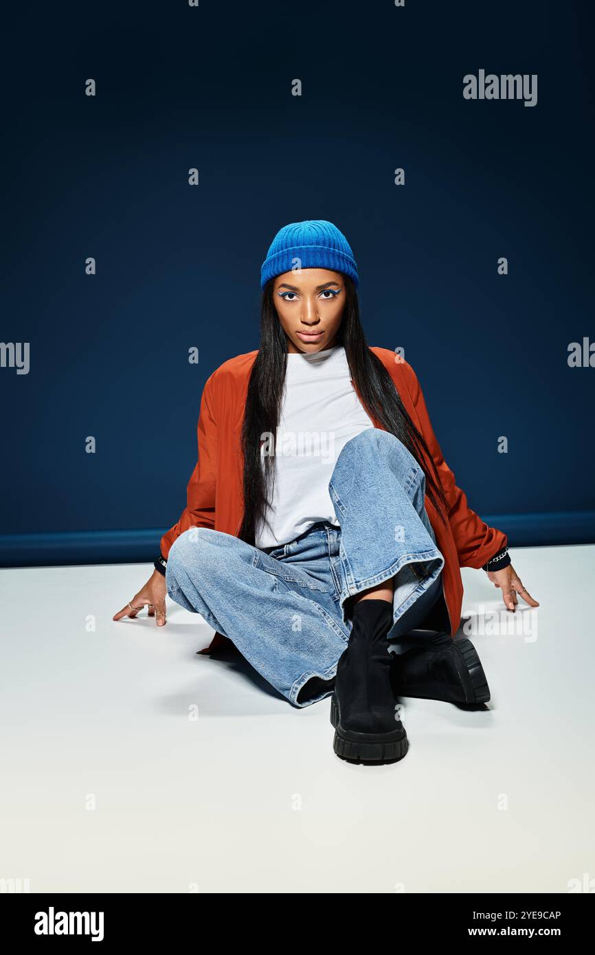 Eine junge Frau drückt ihr Gespür für Mode mit Herbstkleidung in einer modernen Innenumgebung aus. Stockfoto