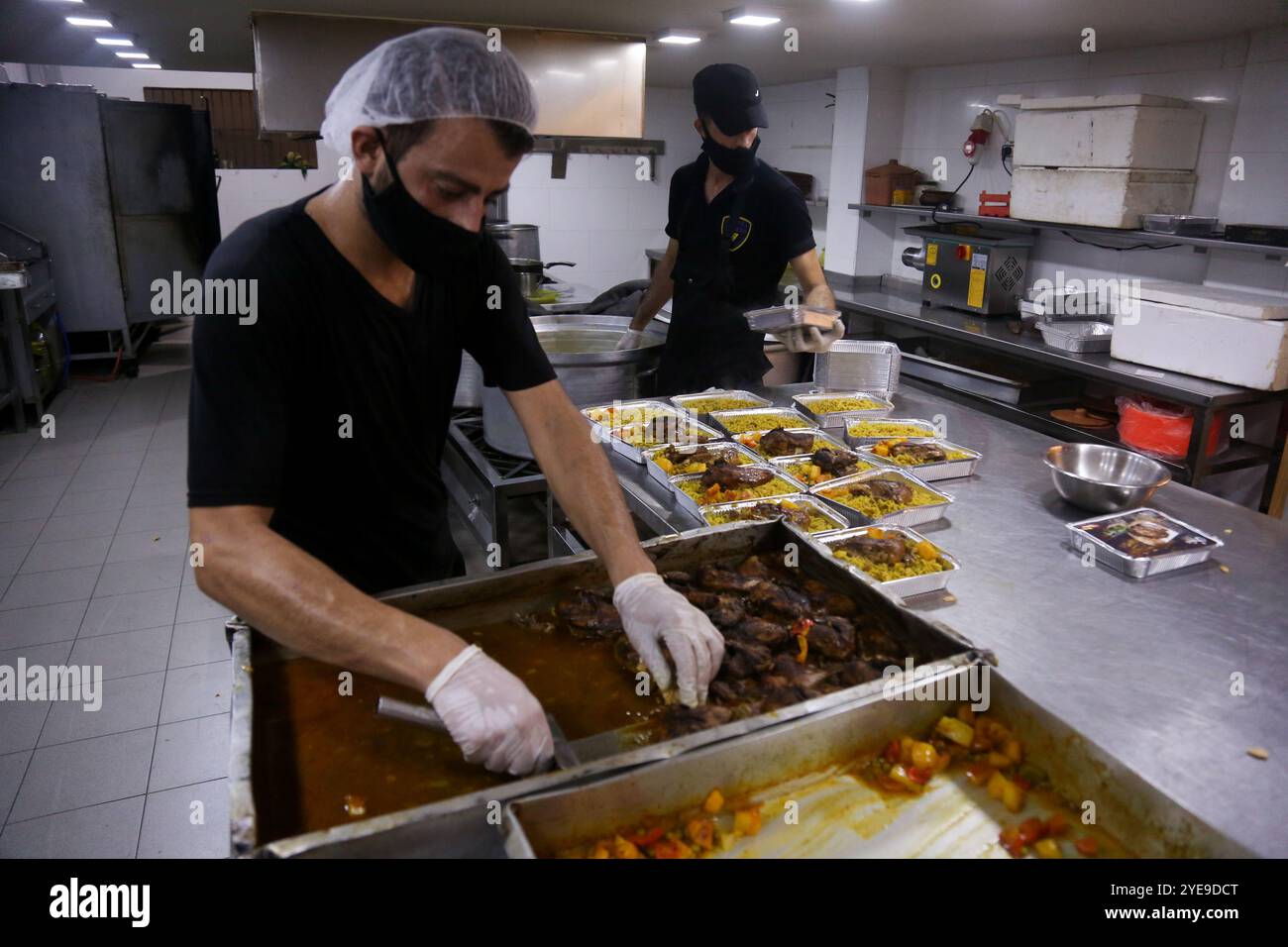 Gaza, Palästina. August 2020. Hunderte von Mahlzeiten werden zubereitet, um Menschen in den Quarantänezentren in Gaza-Stadt zu ernähren. In der vergangenen Woche wurden erstmals COVID-19-Fälle in der Gemeinschaft des dicht besiedelten Gazastreifens entdeckt, was tiefe Bedenken darüber aufwirft, dass sein überlastetes und unzureichendes Gesundheitssystem bald überfordert werden könnte. Die Fälle des Coronavirus haben in der belagerten Küstenenklave in der Tat stetig zugenommen, da die Gesundheitskrise durch die aktuellen Spannungen mit Israel verschärft wurde, die verhindern, dass Treibstoff in Gaza eindringt und schwere Stromknappheit verursacht Stockfoto