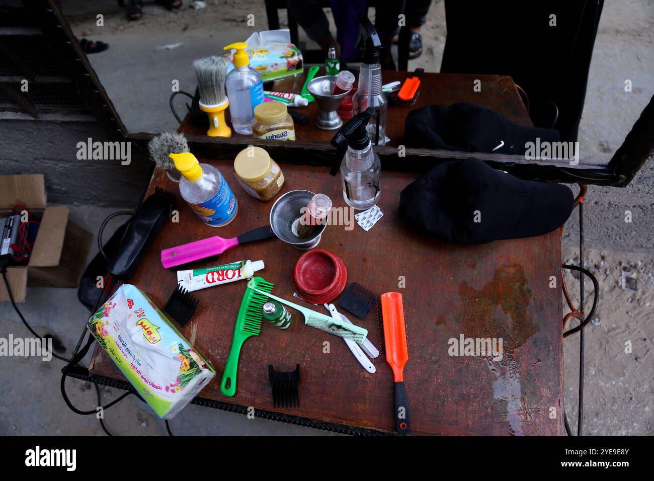 Gaza, Palästina. 31. August 2020. Die Haarschneidewerkzeuge auf einem Tisch in einer engen Gasse vor dem Haus des palästinensischen Friseurs Sameh Al-Qassas in Gaza-Stadt. Sameh trägt Masken und Handschuhe, desinfiziert ständig seine Werkzeuge und verteilt Handdesinfektionsmittel, während er Kindern, die auf kurze Distanz sitzen, Haarschnitte gibt. Der drastische Anstieg der COVID-19-Infektionen seit der Aufdeckung der ersten Gemeinschaftsfälle Anfang letzter Woche im Gazastreifen hat die palästinensischen Behörden alarmiert, die eine strenge Abriegelung verhängt und die Bewohner dringend aufgefordert haben, soziale Distanzierung im dicht besiedelten Streifen zu verfolgen. T Stockfoto