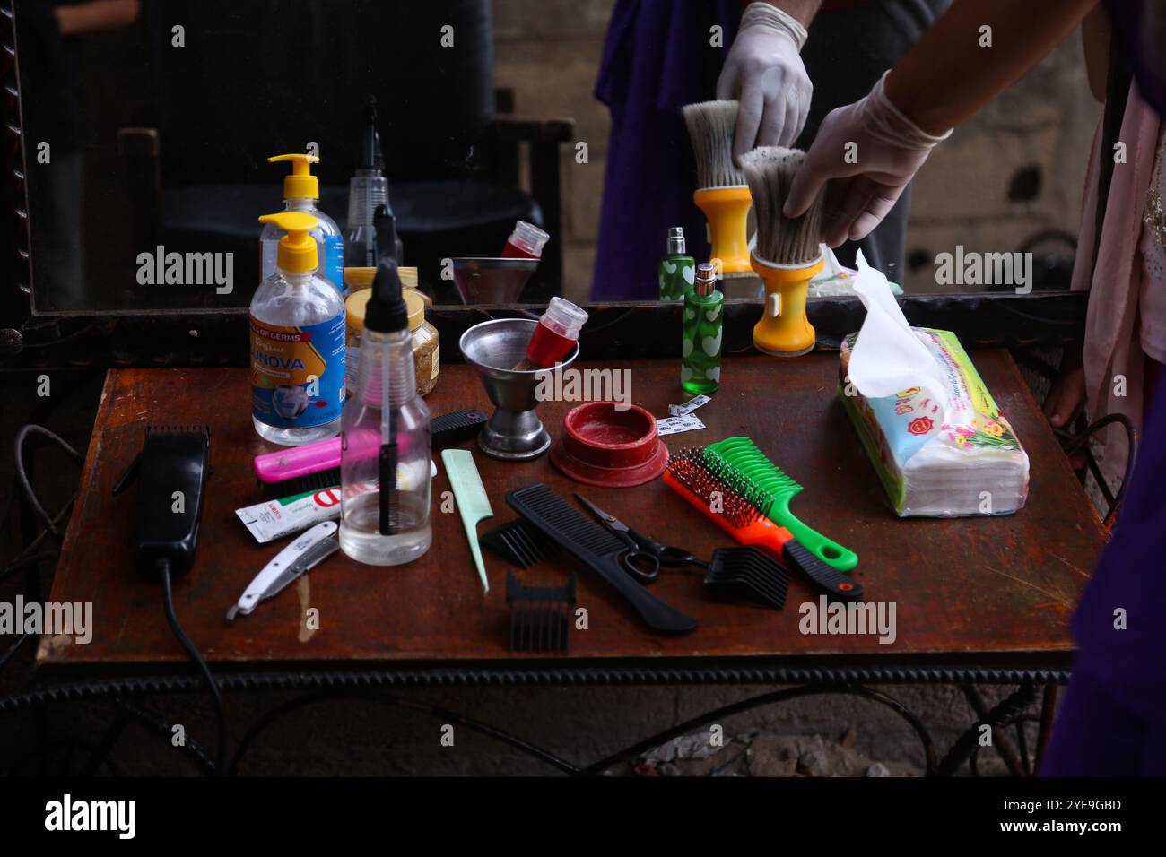 Gaza, Palästina. 31. August 2020. Die Haarschneidewerkzeuge auf einem Tisch in einer engen Gasse vor dem Haus des palästinensischen Friseurs Sameh Al-Qassas in Gaza-Stadt. Sameh trägt Masken und Handschuhe, desinfiziert ständig seine Werkzeuge und verteilt Handdesinfektionsmittel, während er Kindern, die auf kurze Distanz sitzen, Haarschnitte gibt. Der drastische Anstieg der COVID-19-Infektionen seit der Aufdeckung der ersten Gemeinschaftsfälle Anfang letzter Woche im Gazastreifen hat die palästinensischen Behörden alarmiert, die eine strenge Abriegelung verhängt und die Bewohner dringend aufgefordert haben, soziale Distanzierung im dicht besiedelten Streifen zu verfolgen. T Stockfoto