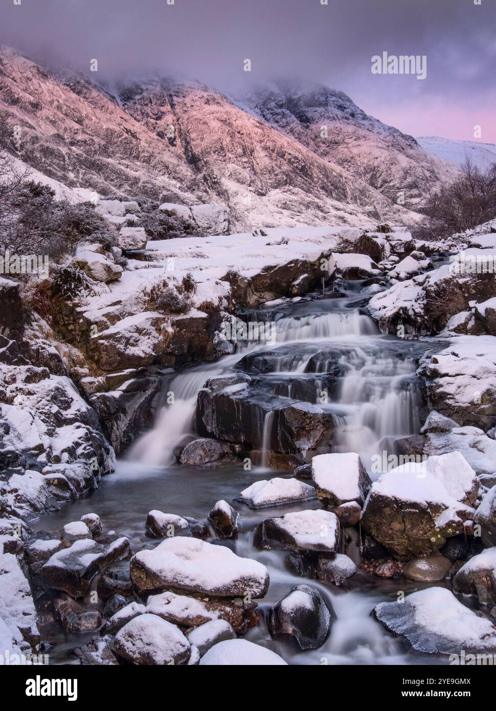 Letztes Licht auf den Clachaig Falls, begleitet von Aonach Eagach und Meal Dearg im Winter, Glencoe, Scottish Highlands, Schottland, Großbritannien Stockfoto