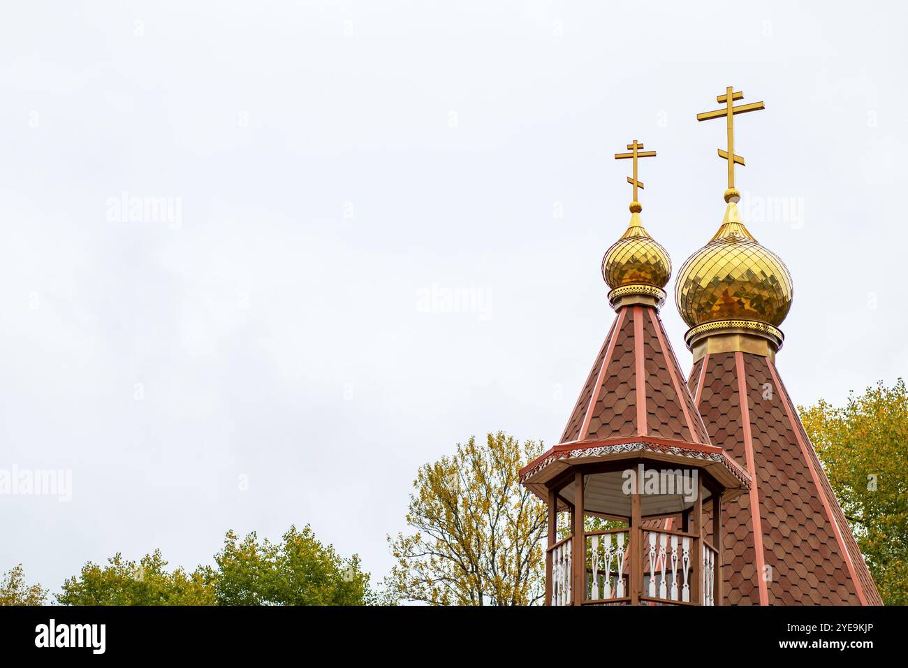 Es gibt ein Kirchengebäude mit zwei goldenen Kreuzen, die ganz oben auf dem Dach stehen und das majestätische Aussehen verstärken Stockfoto