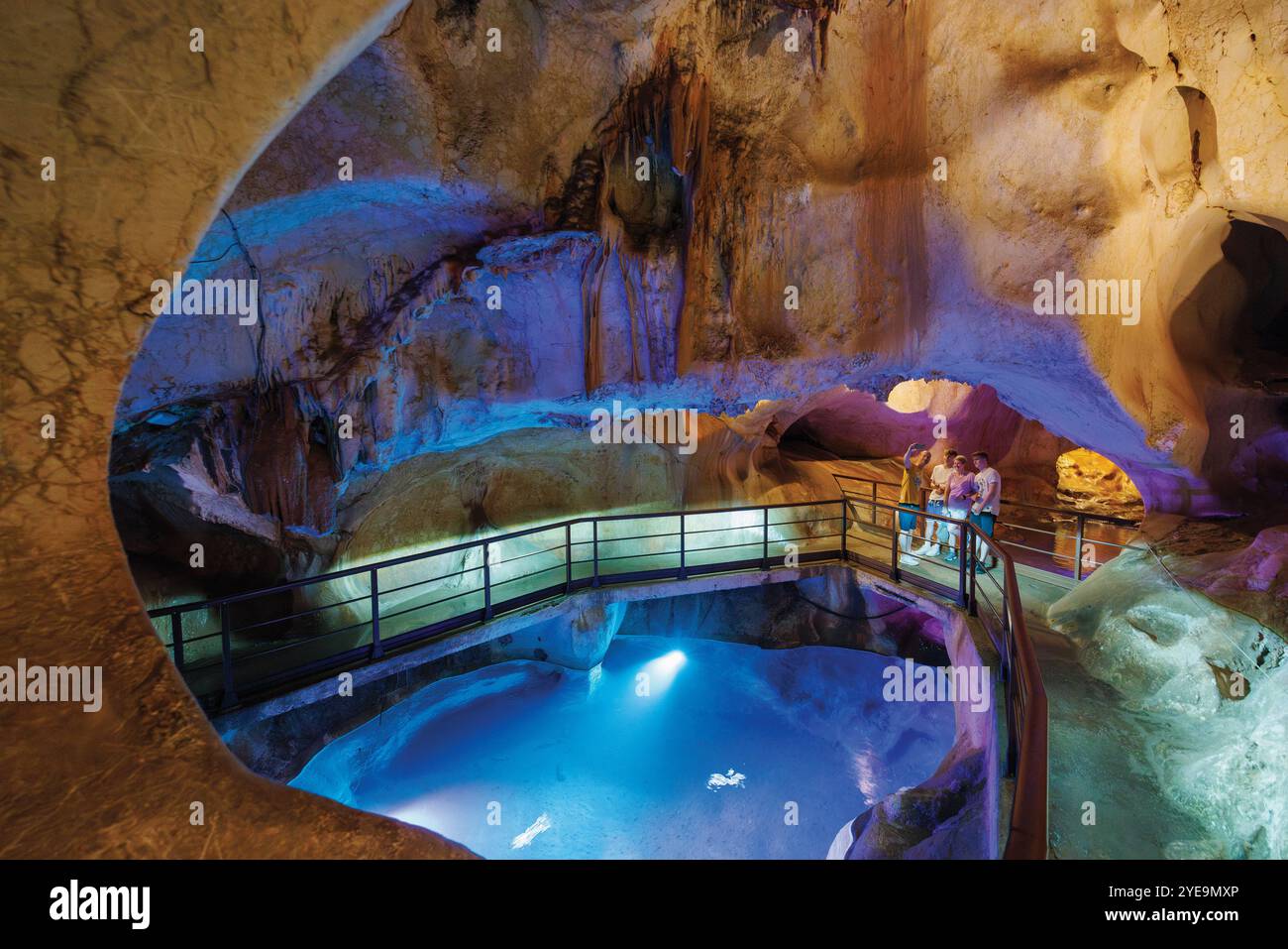 Touristen stehen auf einem Pfad in einer beleuchteten Meereshöhle, der Schatzhöhle, in Malaga, Spanien; Rincon de la Victoria, Costa del Sol, Provinz Malaga, Spanien Stockfoto