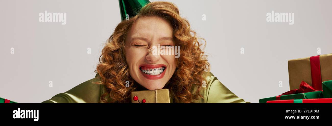 Eine junge Frau, die festliche Kleidung trägt, lächelt beim Posen hell. Stockfoto