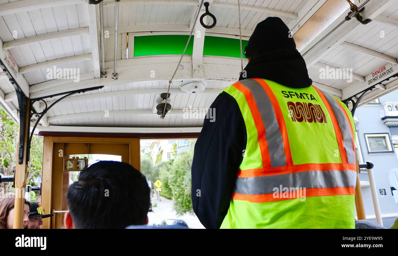 Der Gripman in der Mitte an Bord einer San Francisco Seilbahn voller Touristen Powell Street San Francisco Kalifornien USA Stockfoto