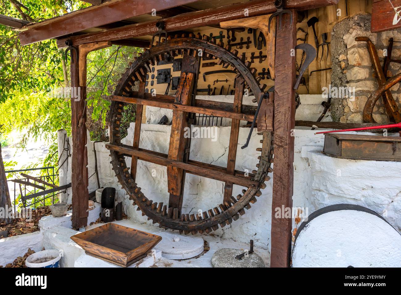 Lefkada. Griechenland- 10.17.2024. Eine handbetriebene Holzmühle und eine Steinmühle sind im Karya Folklore Museum zu sehen. Stockfoto