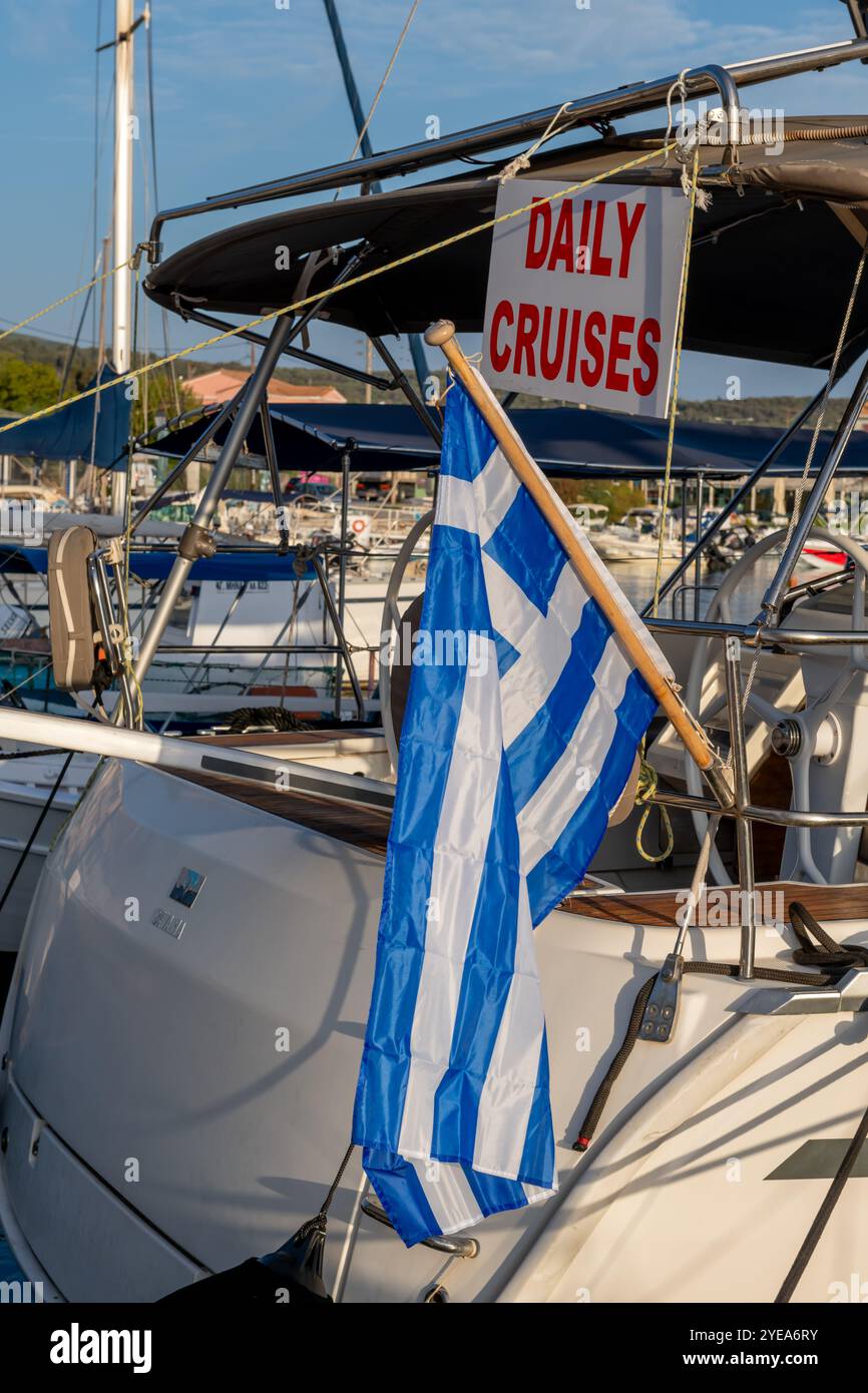 Lefkada, Griechenland- 10.18.2024. Ein Schild auf einer Segelyacht im Hafen, das Touristen tägliche Kreuzfahrten entlang der griechischen Flagge anbietet. Stockfoto