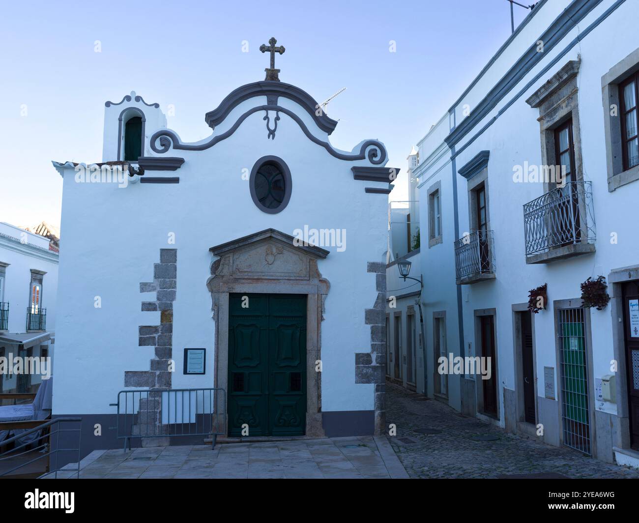 Kleines weißgetünchtes Kirchengebäude in der Stadt Tavira, Portugal. Tavira ist eine kleine Stadt an der portugiesischen Algarve und erstreckt sich über den Gilao River Stockfoto