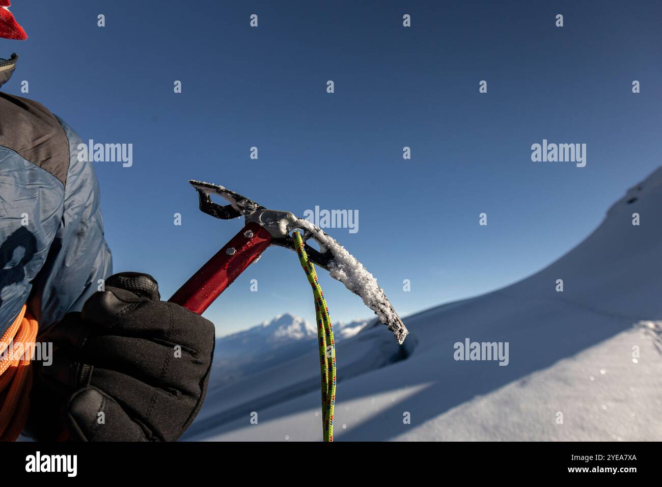 Die Hände des Mannes halten eine Schneaxt, Sicherheitsausrüstung für Schneeklettern Stockfoto