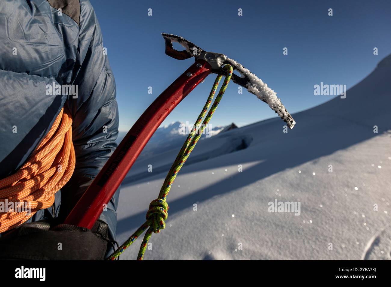 Die Hände des Mannes halten eine Schneaxt, Sicherheitsausrüstung für Schneeklettern Stockfoto