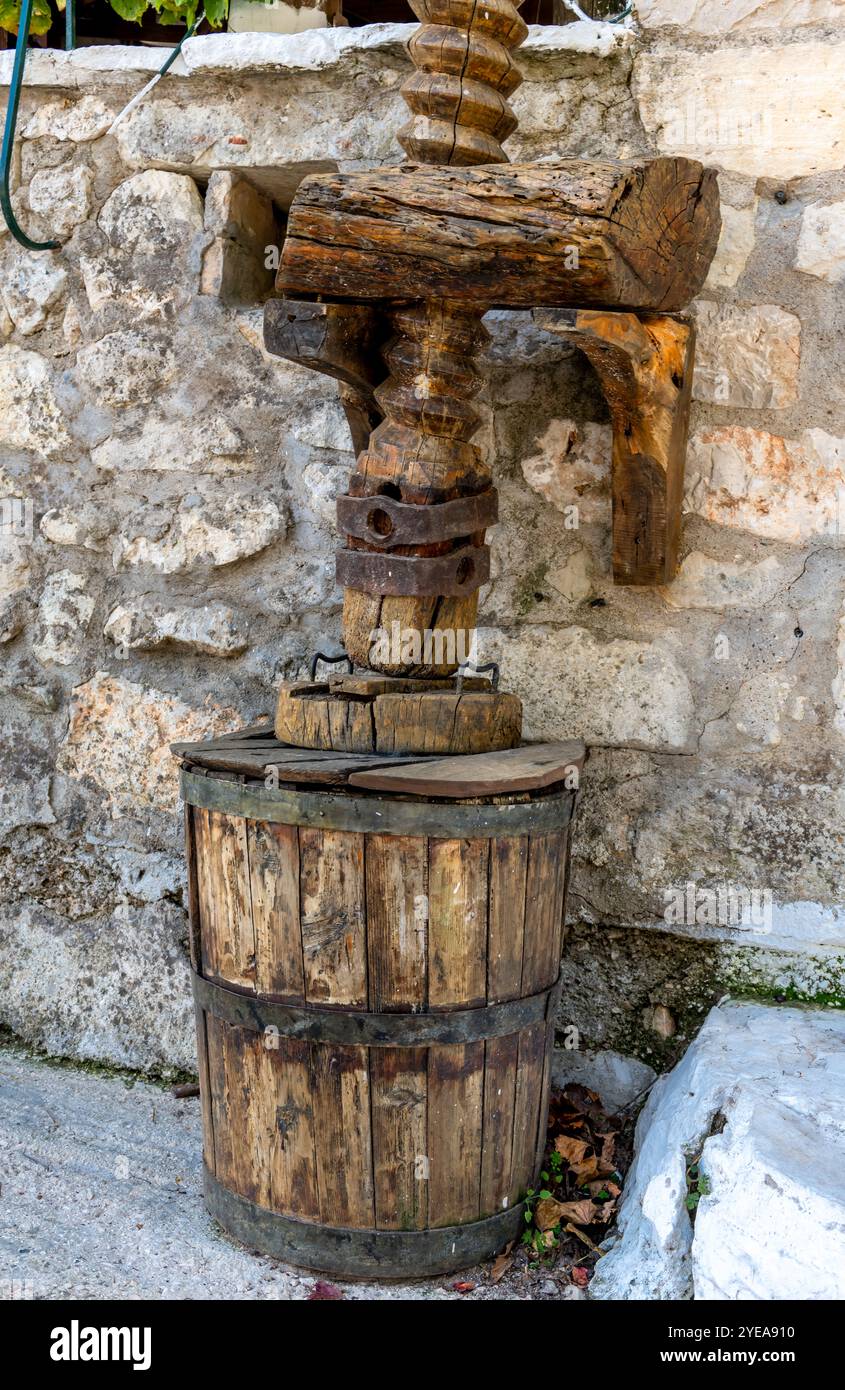 Eine alte, alte Holzpresse und Fässer für die Herstellung von Wein oder Olivenöl. Stockfoto