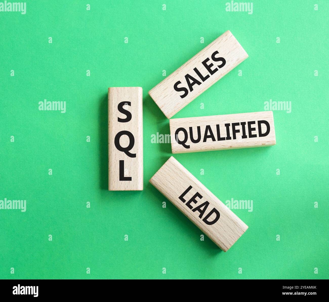 SQL - qualifizierter Lead für Vertrieb. Holzwürfel mit SQL-Wörtern. Schöner grüner Hintergrund. Business- und SQL-Konzept. Kopierbereich. Stockfoto