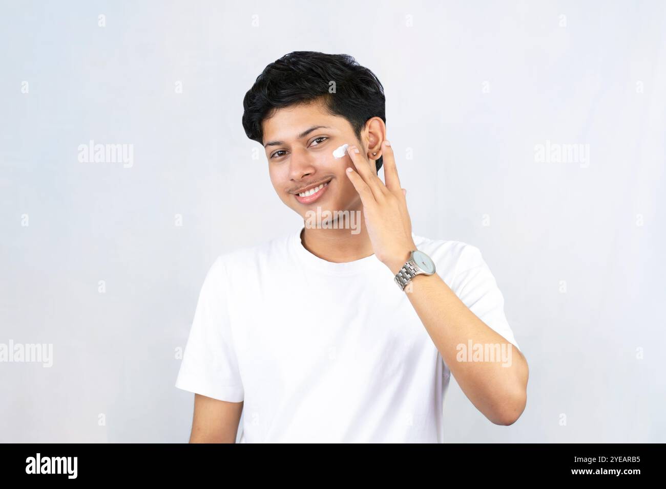 Junge Teenager Modell männlich mit Akne Schönheit Produkt Hautpflege isoliert mit Feuchtigkeitscreme Gesture Stockfoto