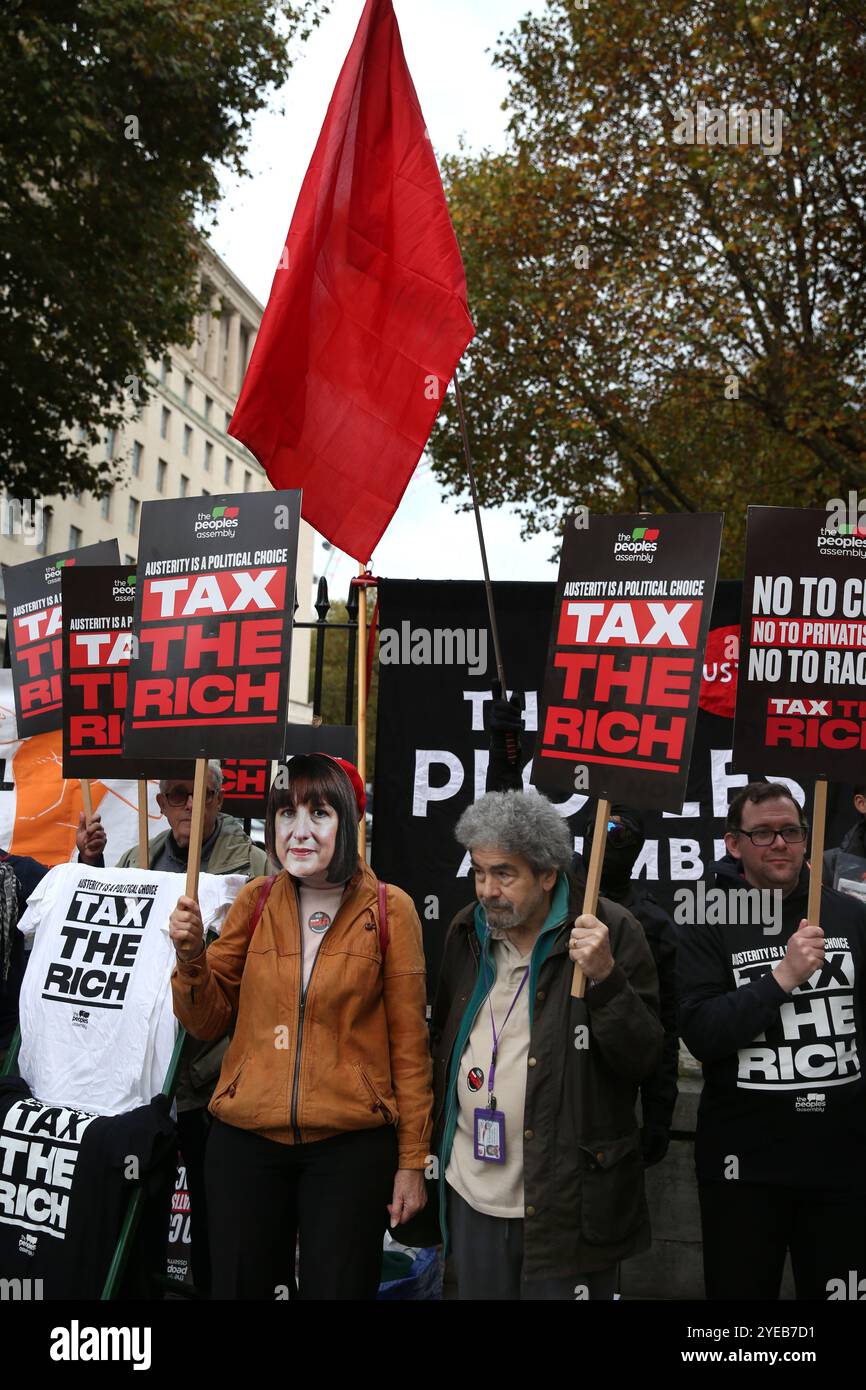 London, England, Großbritannien. 30. Oktober 2024. Eine Gruppe von Demonstranten versammelt sich in Whitehall mit den Zeichen „˜Tax the Rich“, einer trägt während der Demonstration eine RACHEL REEVES Maske. Demonstranten, die die Volksversammlung unterstützen, geben ihre Antwort auf RACHEL REEVES erstes Budget, indem sie gegenüber der Downing Street protestieren. Sie fordern ein Ende der Austerität und die "˜Besteuerung der Reichen" und nicht die Armen. (Kreditbild: © Martin Pope/ZUMA Press Wire) NUR REDAKTIONELLE VERWENDUNG! Nicht für kommerzielle ZWECKE! Stockfoto