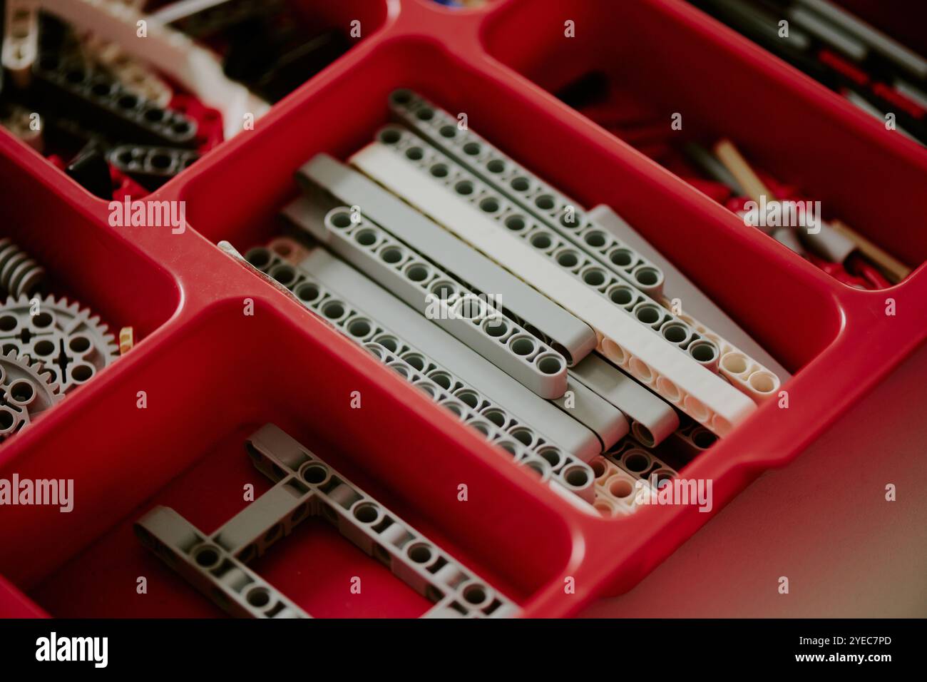 Mittlere Nahaufnahme von grauen Ersatzteilen in roter Kunststoffzelle des Behälters Stockfoto