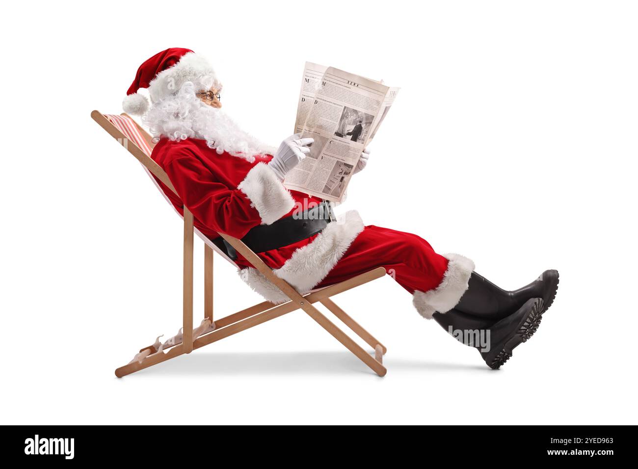 weihnachtsmann liest eine Zeitung und sitzt auf einem Liegestuhl isoliert auf weißem Hintergrund Stockfoto