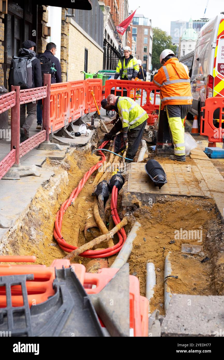 Arbeiter, die rote Stromkabel unter Pflaster ersetzen, im neuen Smithfield Market Area in der Charterhouse Street London EC1 2024 Britain KATHY DEWITT Stockfoto