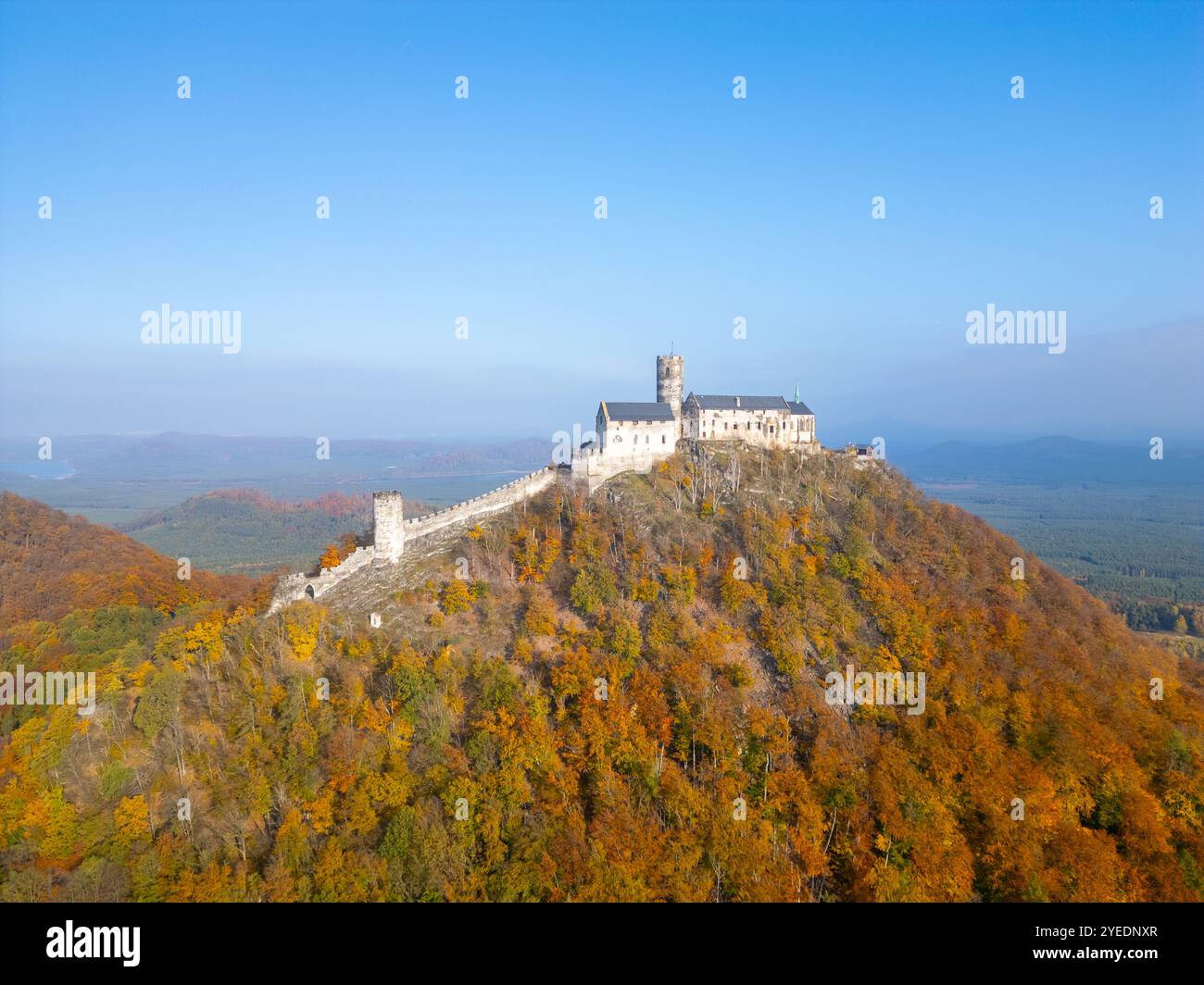 Die mittelalterliche Burg Bezdez steht stolz auf einem Hügel, umgeben von lebhaftem Herbstlaub. Die Landschaft zeigt eine atemberaubende Mischung aus Farben, die die Schönheit der Saison widerspiegelt. Stockfoto