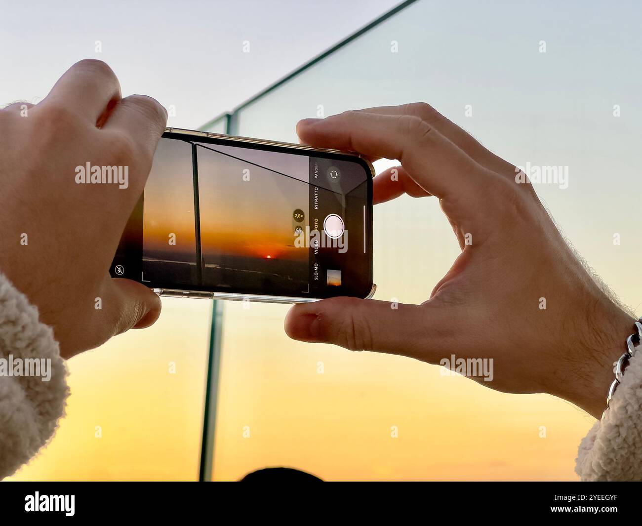 Hände einer Person, die ein Smartphone benutzt, um einen Sonnenuntergang von manhattan New york City von der Aussichtsplattform des Randes hudson Yards nyc aufzunehmen - Smartphone-aufgenommenes Stockfoto