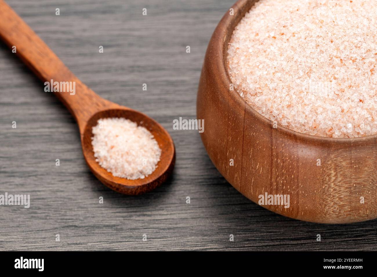 Feines Himalaya-Salz in Schüssel und Löffel - Rosa Kristalle Stockfoto
