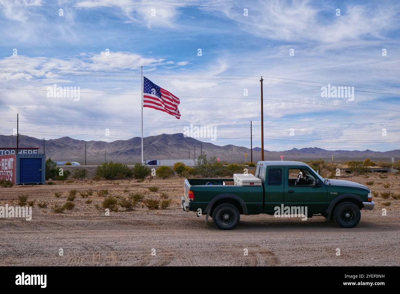 Pick-up-Truck parkt auf der Landstraße neben der US-Flagge an der Truckstop an der Route 93, Mojave County, Arizona. Stockfoto