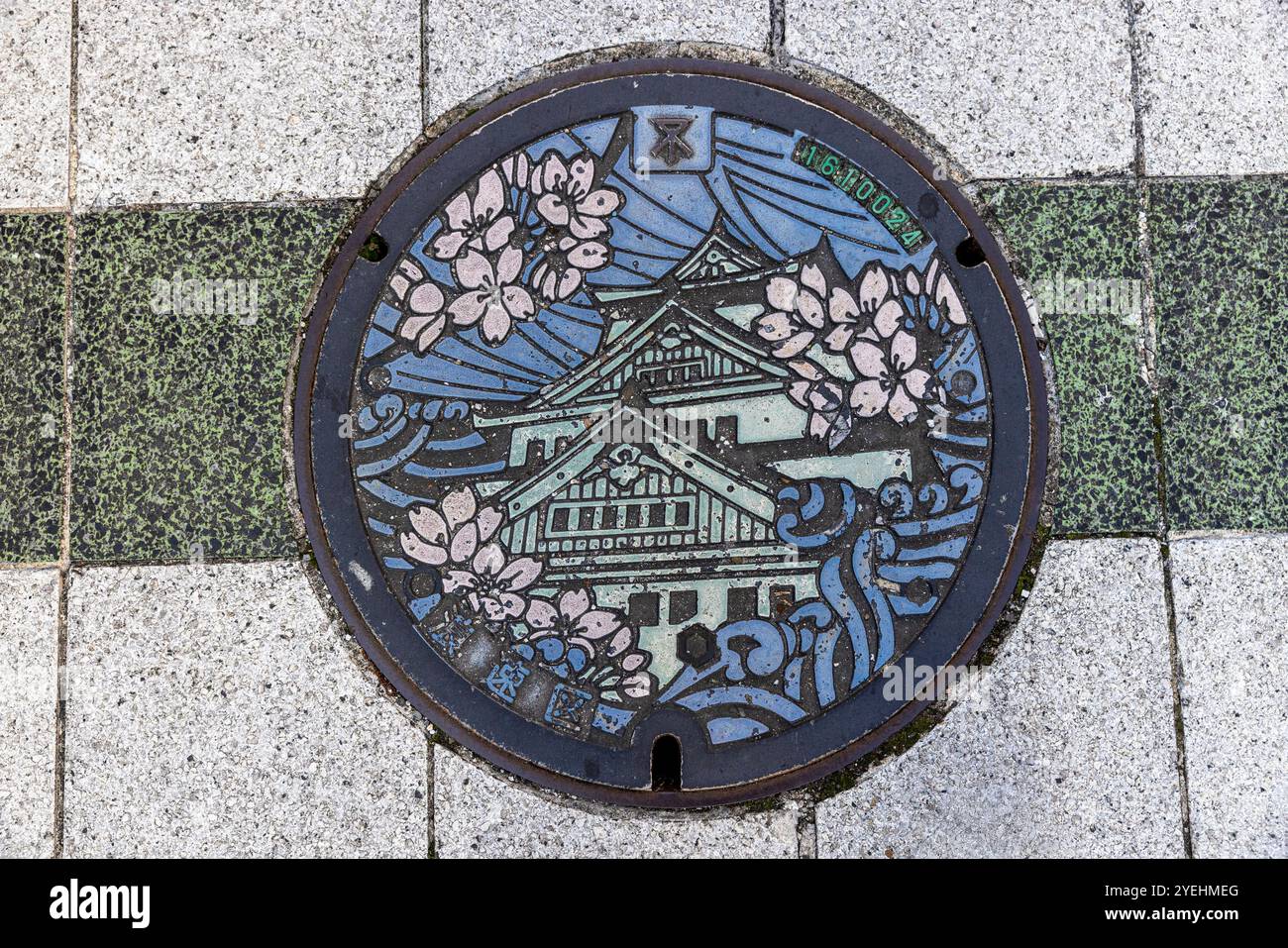 Kanaldeckel traditionelle japanische Burg umgeben von Kirschblüten Stockfoto