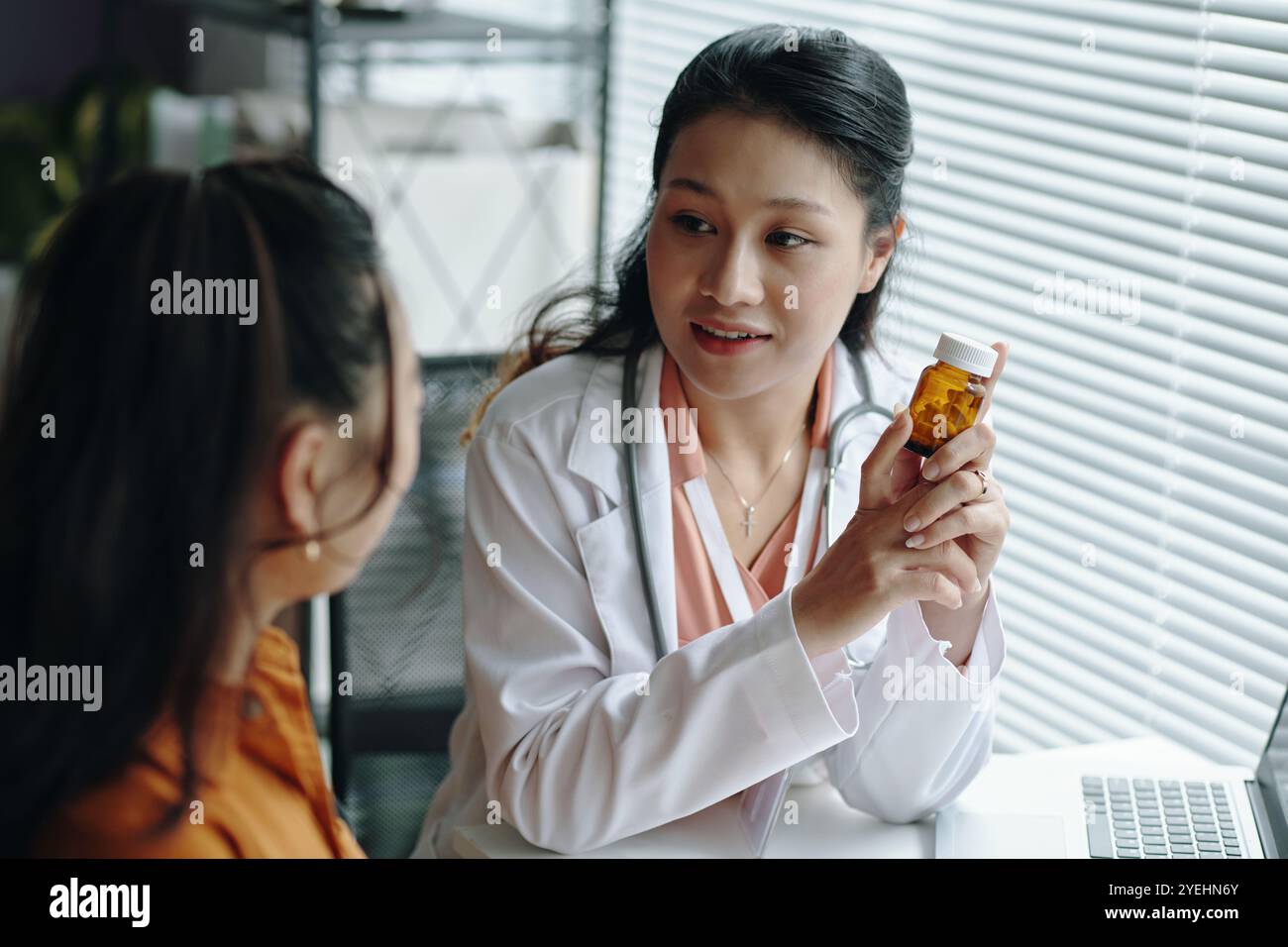 Asiatische Apothekerin Diskutiert Medikamentöse Vorteile Stockfoto