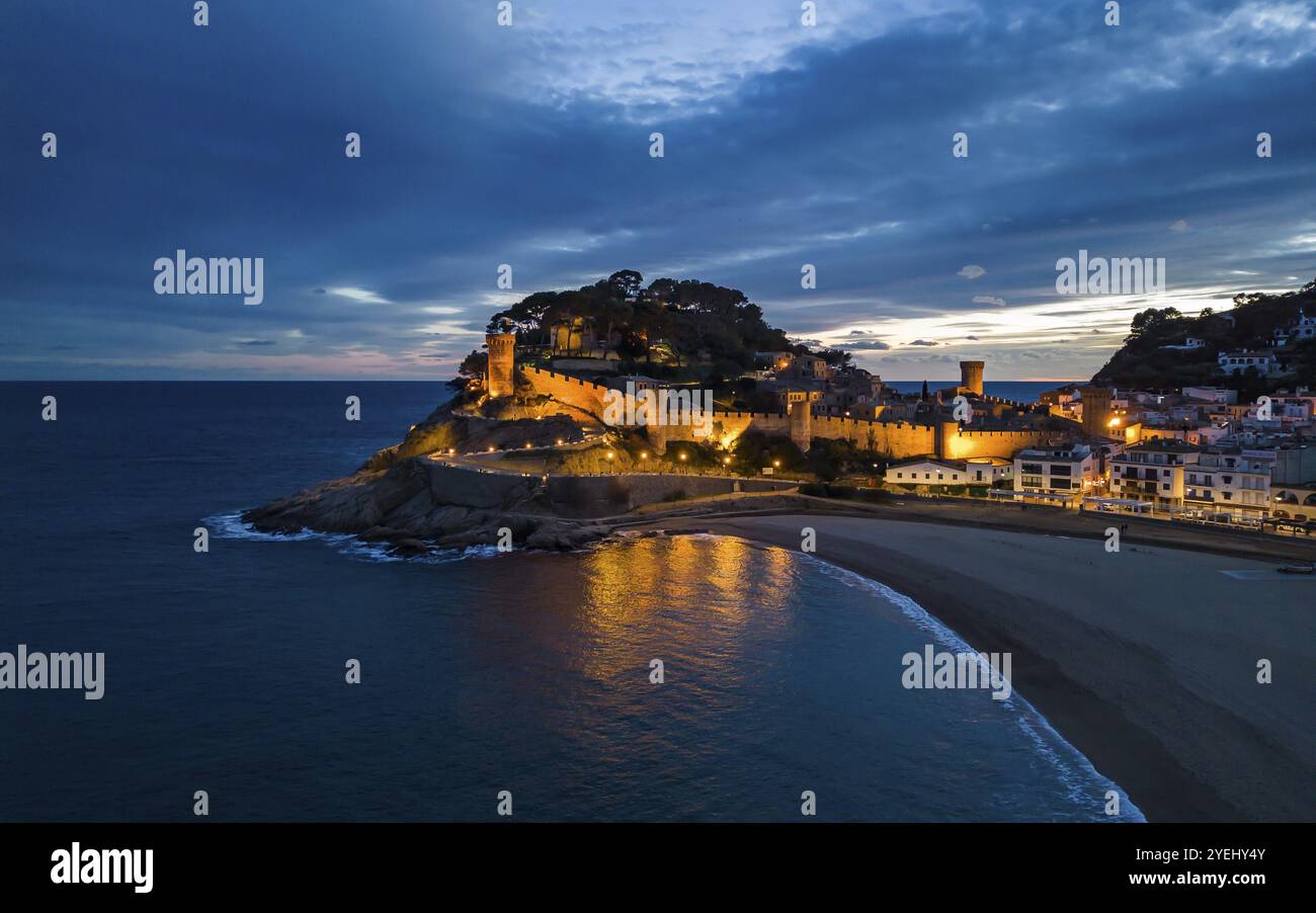 Eine mittelalterliche Küstenburg, beleuchtet in der Abenddämmerung mit einem Sandstrand und Meer vor einem wolkenblauen Himmel, Tossa de Mar, Katalonien, Spanien, Europa Stockfoto