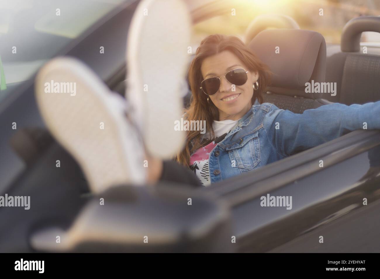 Glückliche junge Frau, die ihr Cabrio genießen Stockfoto