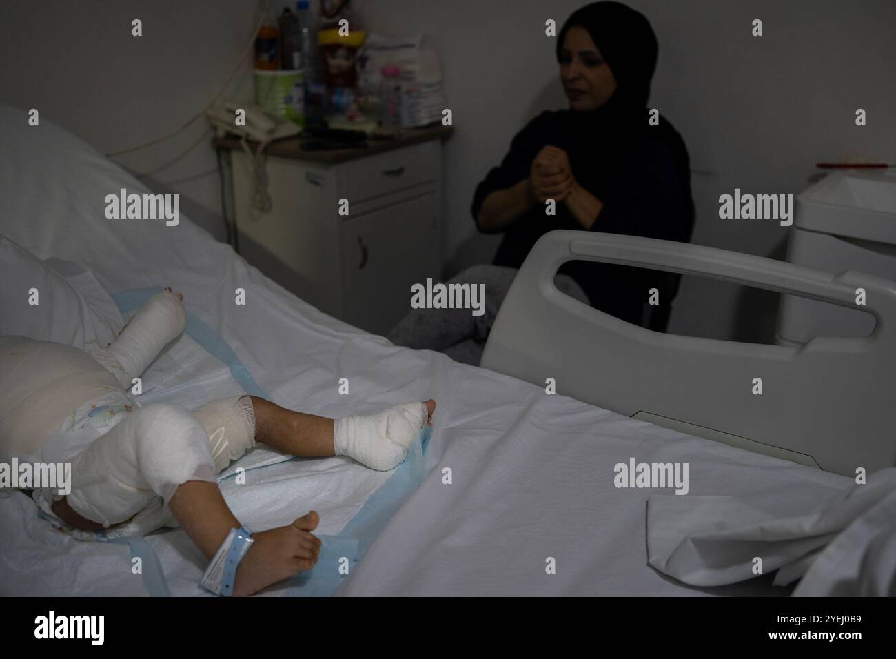 Fatima beobachtet ihre Tochter, zwei, die bei einem israelischen Luftangriff am 21. Oktober 2024 im libanesischen Krankenhaus Geitaoui in B schwer verbrannt wurde Stockfoto