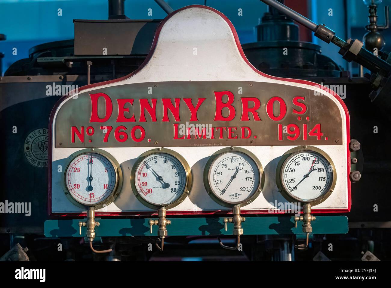 Das Bild zeigt eine Vintage-Dampfmaschine mit einem Bedienfeld mit großen, runden Manometern. Stockfoto