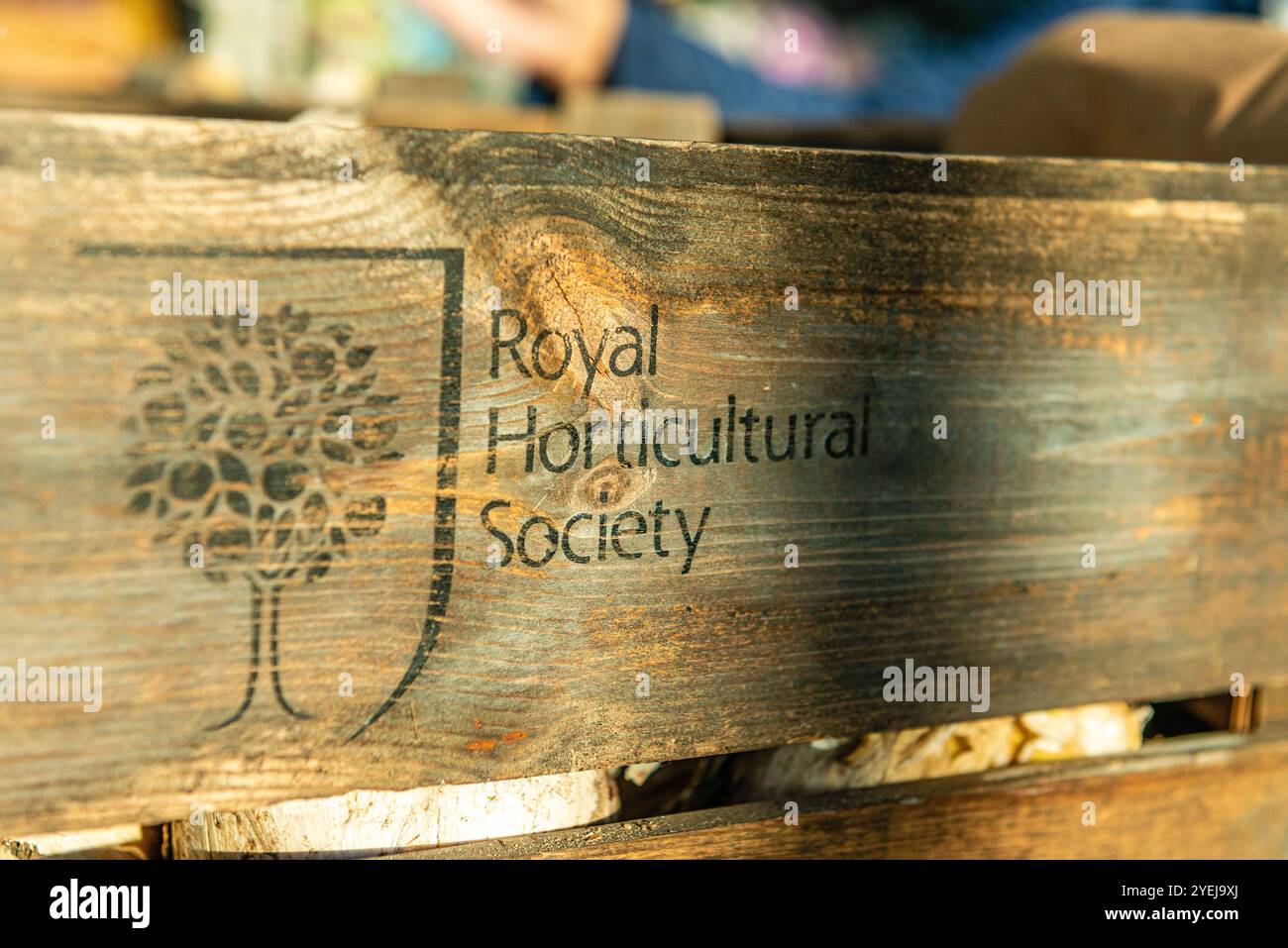 Hölzernes Schild im RHS Harlow Carr, Harrogate, North Yorkshire, Großbritannien mit dem Logo der Royal Horticultural Society Stockfoto