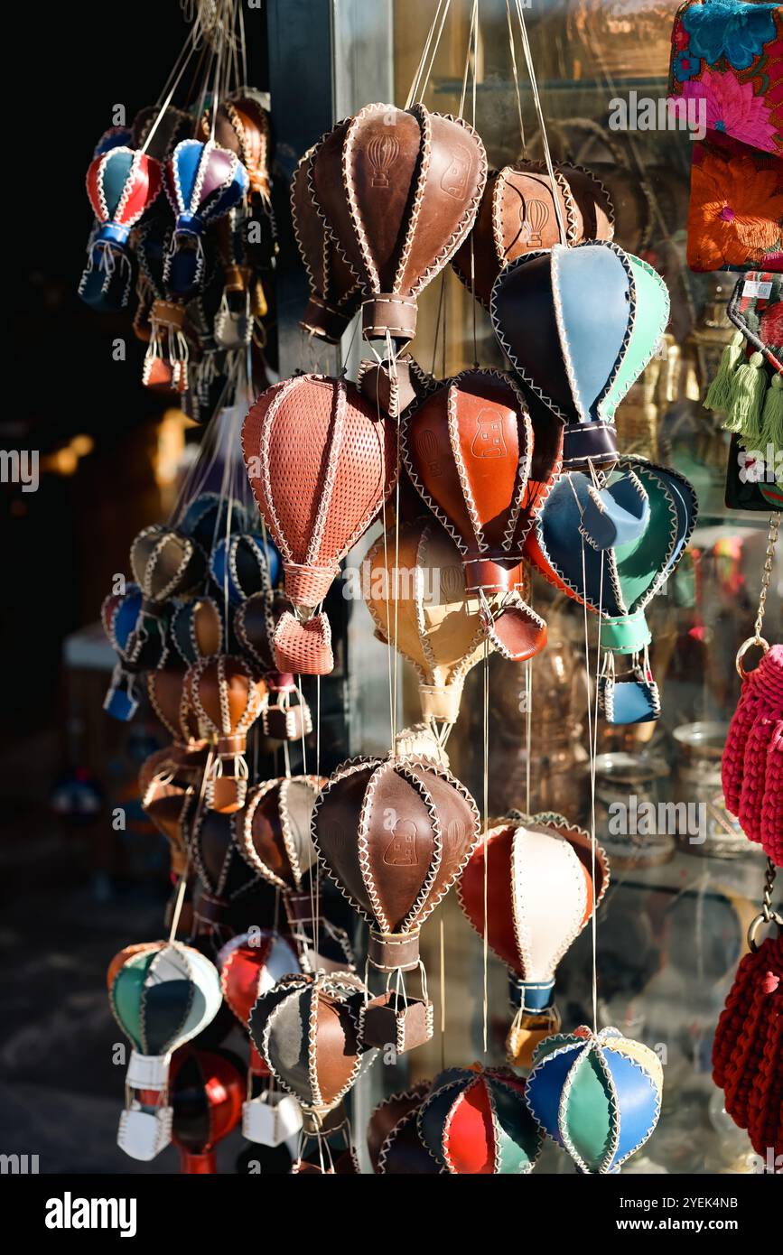 Lebendige handgefertigte Heißluftballondekorationen werden vor einem lokalen Geschäft in Kappadokien zum Verkauf angeboten. Die fröhlichen Dekorationen zeigen die Region Stockfoto