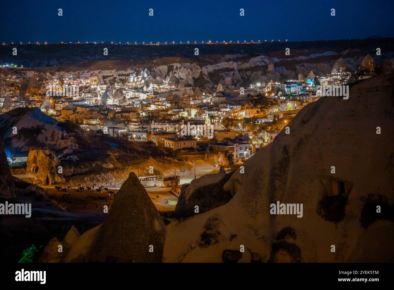 Wenn die Nacht über Kappadokien fällt, funkeln die Lichter des Dorfes vor den markanten Felsformationen. Die ruhige Landschaft zeigt das einzigartige der Region Stockfoto