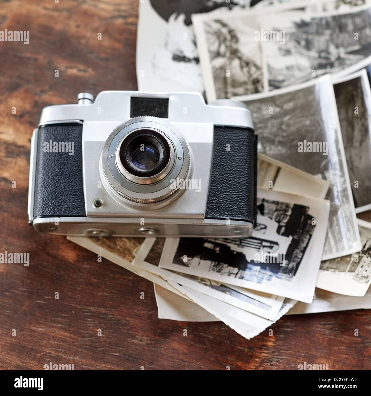 Holzschreibtisch, Vintage und Kamera mit Vintage-Fotos auf Schwarzweiß. Digital, Old School und Tisch mit Bildern für Kreativität, Projekt und Stockfoto