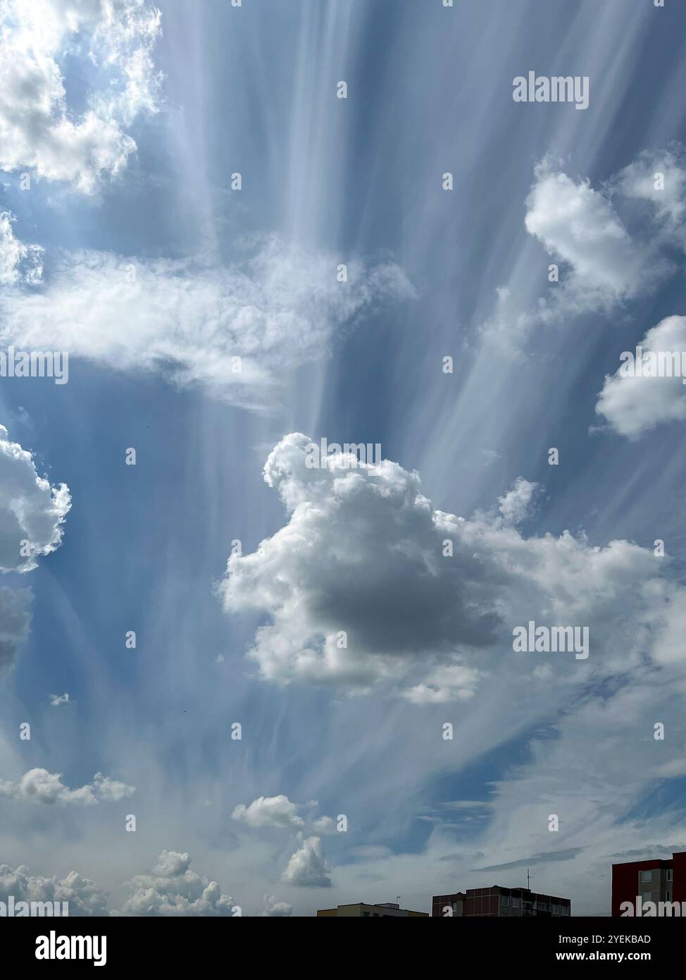 Blauer Himmel mit weißen Wolken, Himmelslandschaft über dem Wohngut, die Sonne scheint hinter den Wolken - Smartphone-aufgenommenes Stockfoto