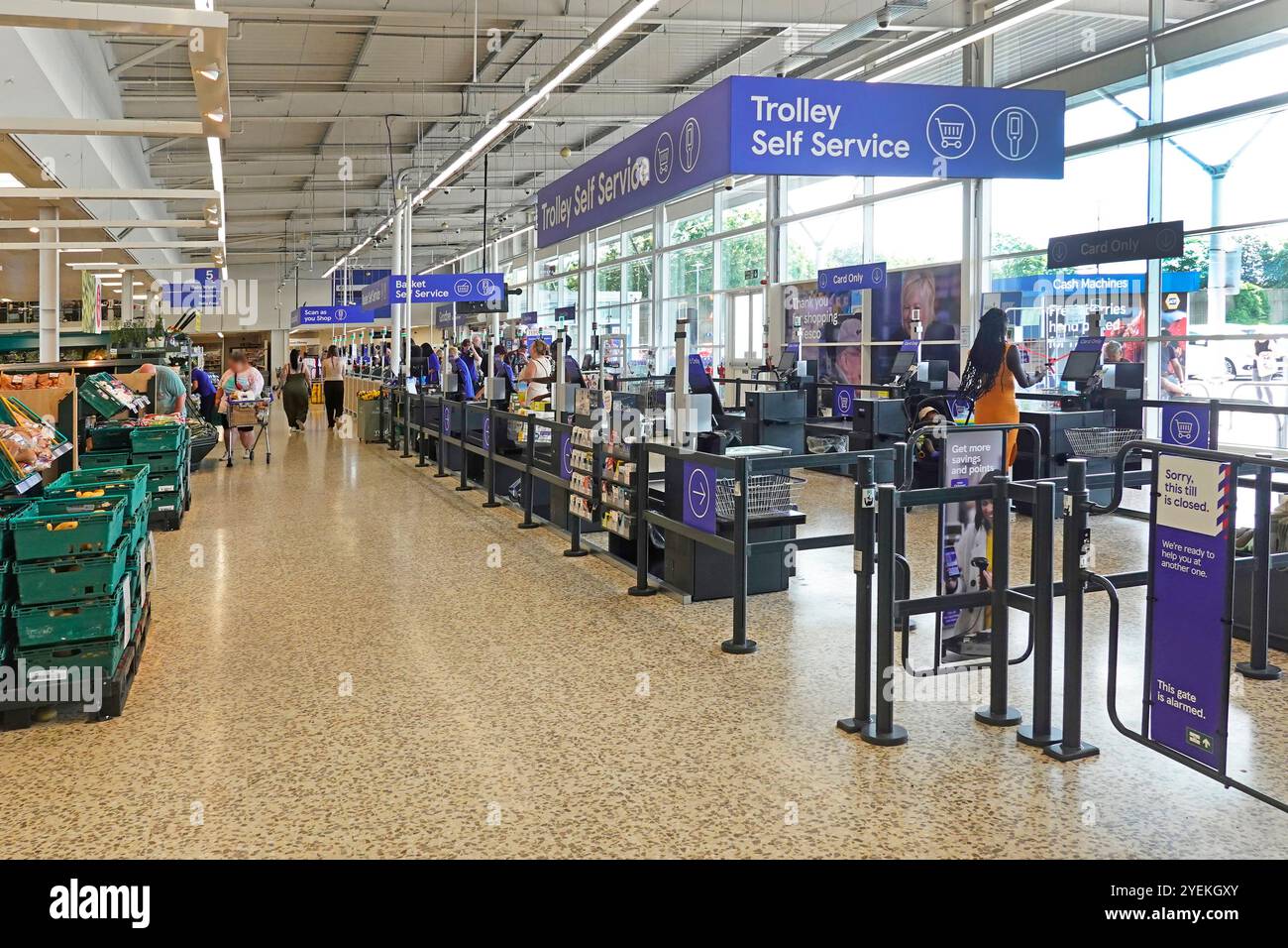 Breite Gänge und Möglichkeiten für Käufer, für Supermarkt-Lebensmittel-Shopping zu bezahlen, einschließlich Trolley Self Service auf glattem, sauberem Terrazzo-Boden London England UK Stockfoto