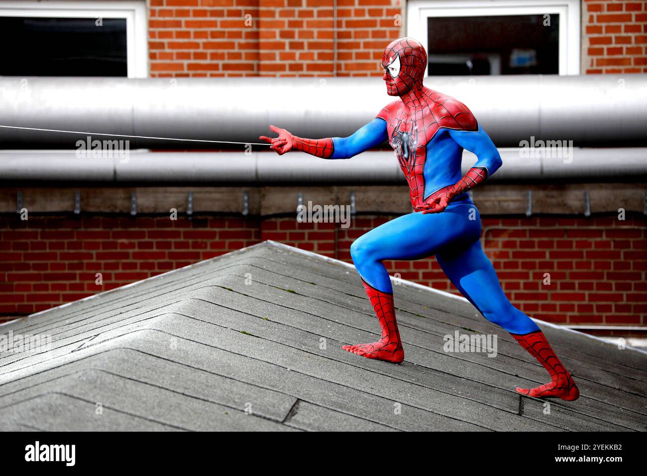 Aus dem COLOR Bodypainting Calendar 2025 - Bodypainting Variations: Spider-man Fotoshooting mit Patrick Kiel auf dem Dach des Hefehofs in Hameln im Rahmen des Geek Art Projektes von Fotograf Tschiponnique Skupin und Bodypainter und Make-up Künstler Enrico Lein. Stockfoto