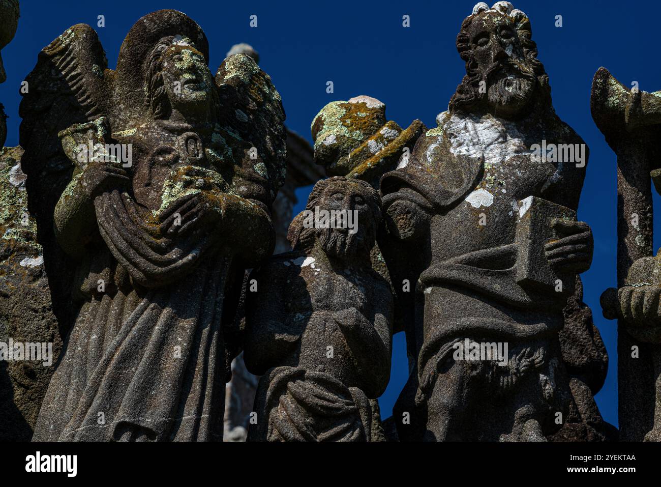 Taufe Christi mit einem Engel links und Johannes dem Täufer rechts. Detail der Skulptur aus den späten 1500er Jahren auf der oberen Ebene der Südwand des Kalvariums in der Pfarrei nahe der Kirche Saint Miliau in Guimiliau, Finistère, Bretagne, Frankreich. Stockfoto