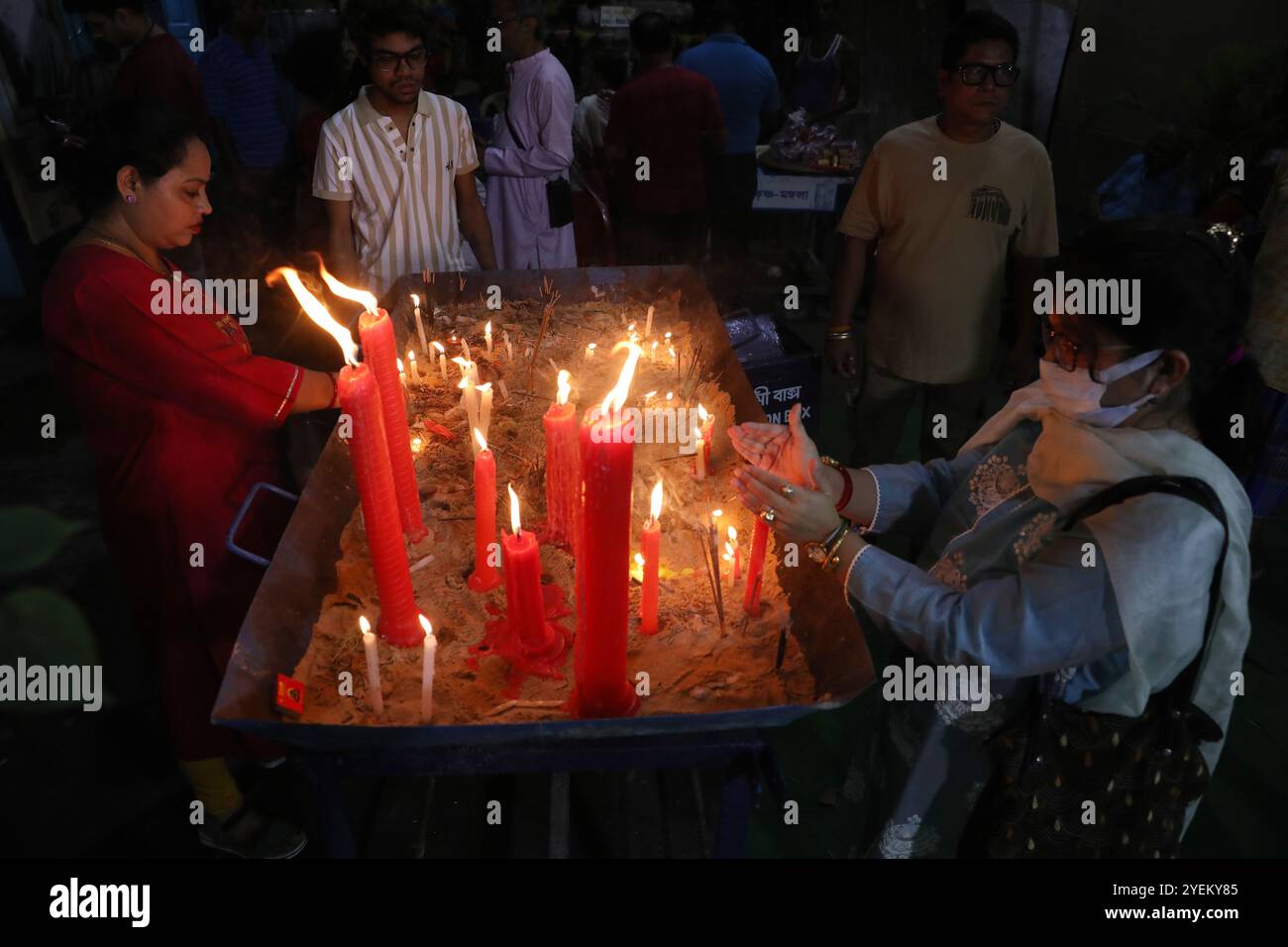 Kalkutta, Indien. 31. Oktober 2024. Ein Gläubiger zündet eine Kerze vor einem „Pandal“ (einer temporären Plattform) an, einer verzierten Struktur, anlässlich des Kali-Puja-Festivals in Kalkata, Indien, am 31. Oktober 2024. Kali ist eine hinduistische Göttin, die die gegensätzlichen Kräfte der Schöpfung und Zerstörung, des Todes und der Wiedergeburt und der Zeit repräsentiert. (Foto: Rupak de Chowdhuri/NurPhoto)0 Credit: NurPhoto SRL/Alamy Live News Stockfoto