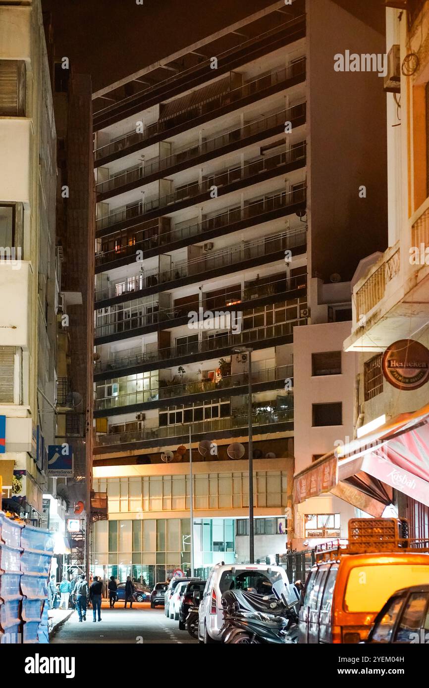 Nächtliche urbane Szene mit einem hohen, mehrstöckigen Gebäude, beleuchtet von künstlichen Lichtern, zeigt 'la Silhouette immeuble' in Casablanca in Marokko Stockfoto