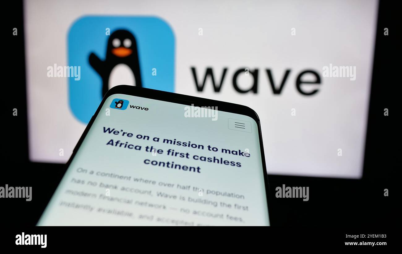 Mobiltelefon mit Website des sengalesischen Unternehmens Wave Mobile Money Inc. Auf dem Bildschirm vor dem Geschäftslogo. Fokussieren Sie sich oben links auf der Telefonanzeige. Stockfoto