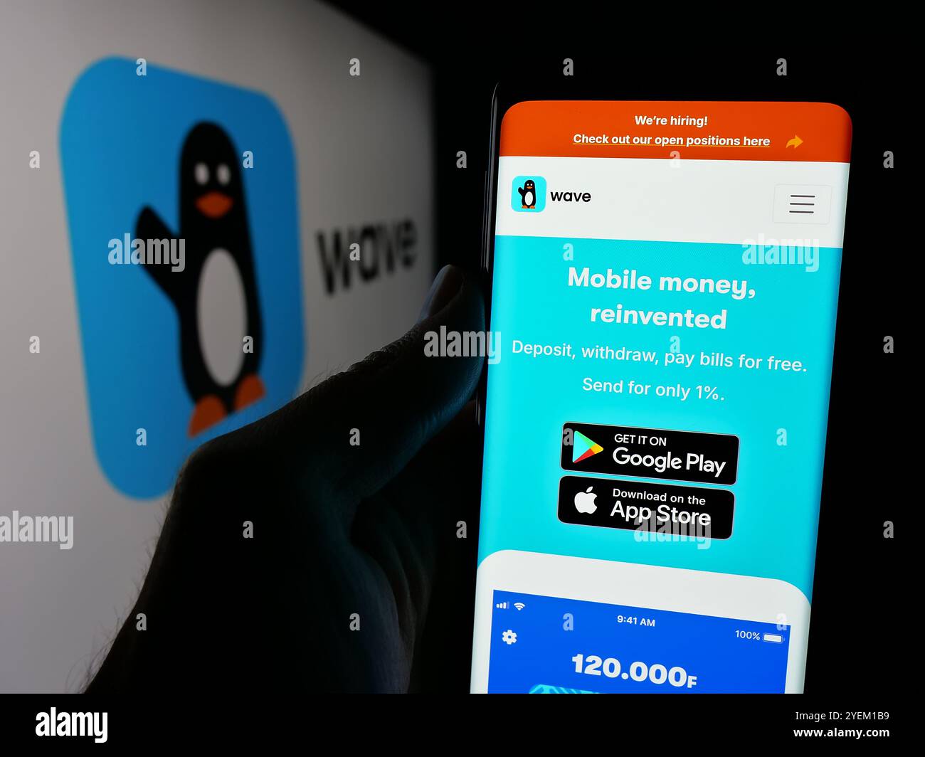 Person, die ein Handy hält, mit der Webseite des sengalesischen Unternehmens Wave Mobile Money Inc. Vor dem Logo auf dem Bildschirm. Konzentrieren Sie sich auf die Mitte des Telefondisplays. Stockfoto